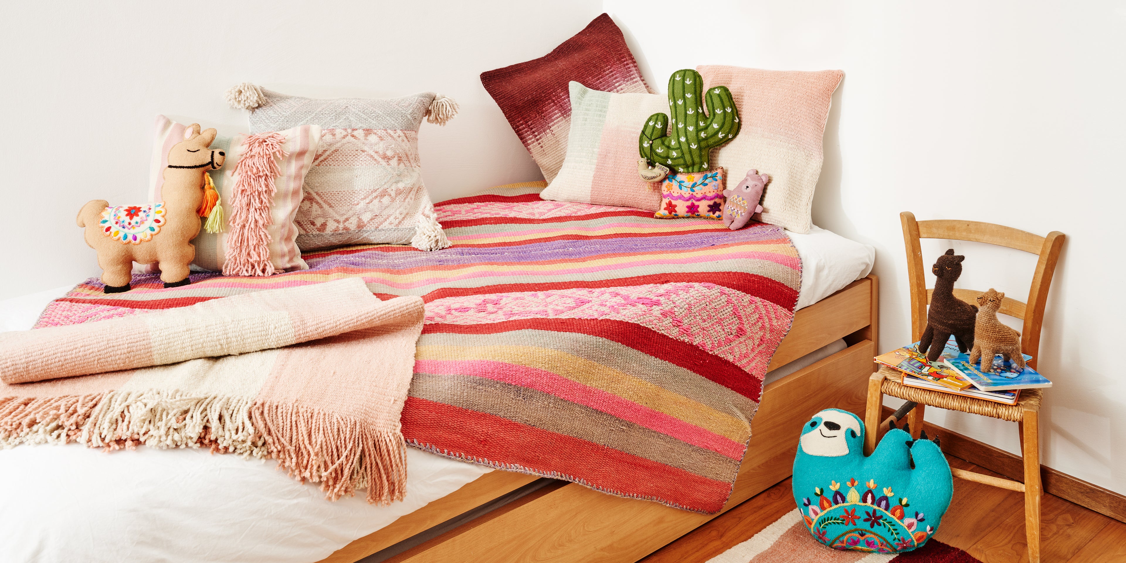 Peruanische Design Kissen, Teppiche und Stofftiere auf einem Bett