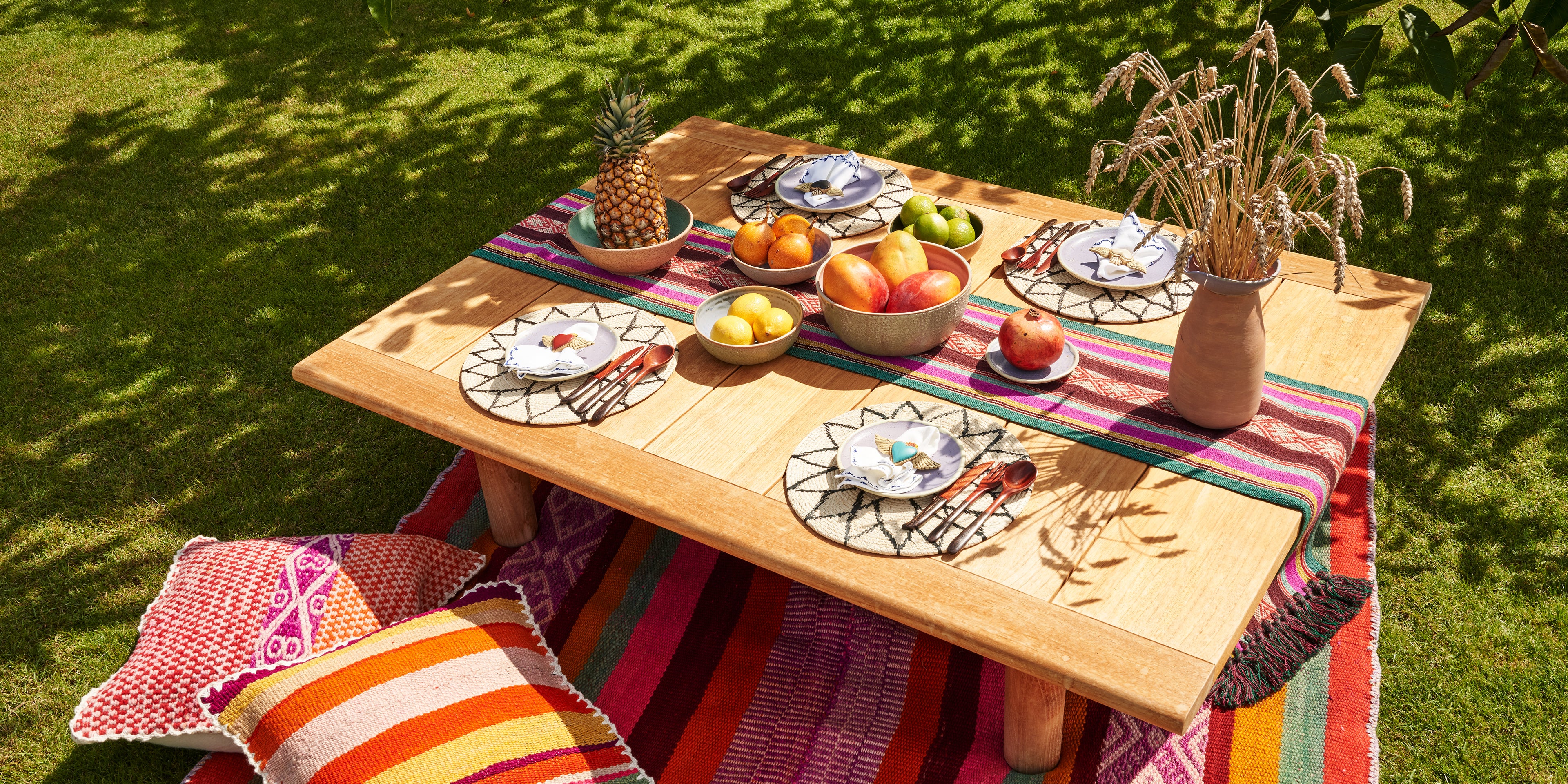 Peruanisch gedeckter Tisch mit farbigem Tischläufer und handgemachter Keramik