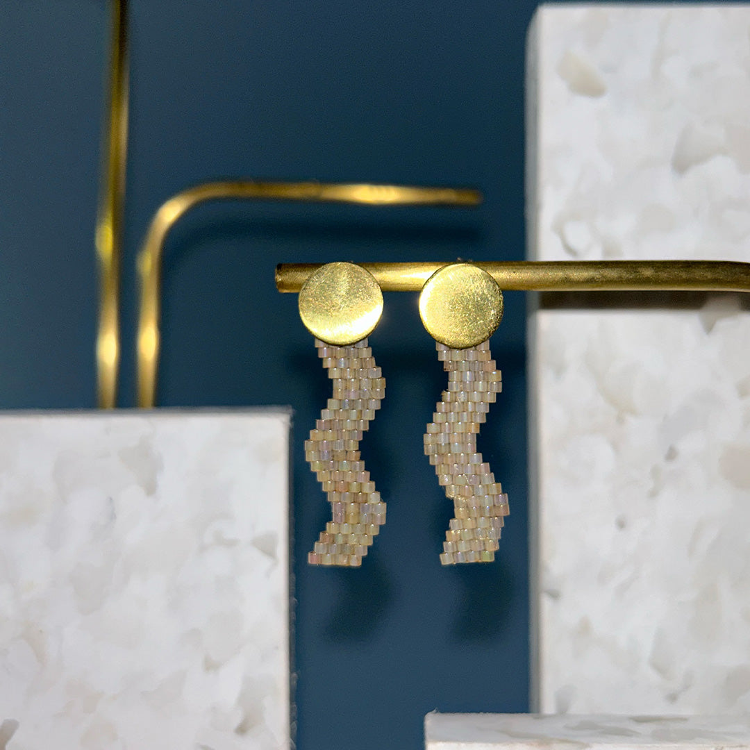 Goldene, hängende Ohrringe mit kleinen perlfarbenen Schmuckperlen