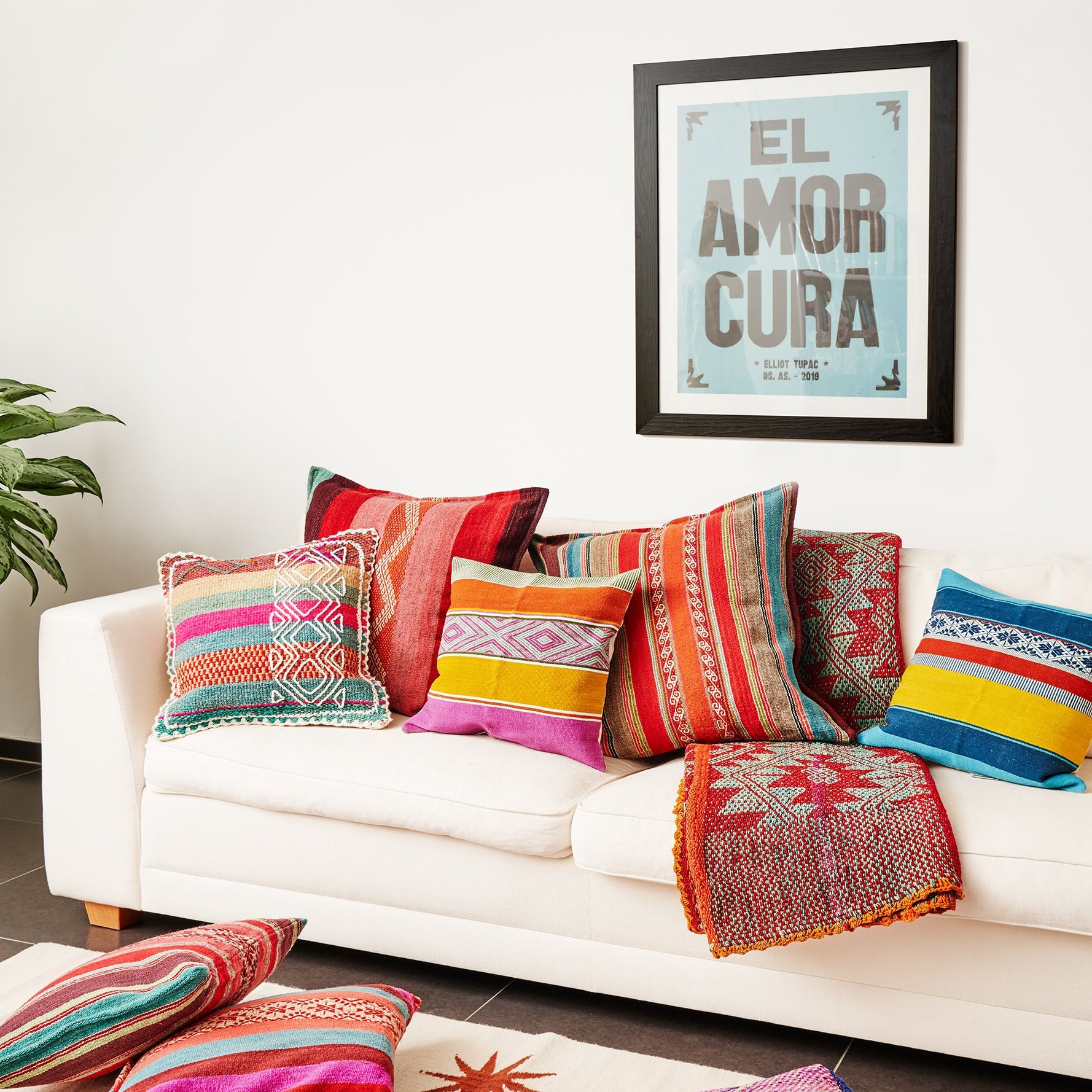 Sofa mit farbigen peruanischen Kissen und blauem Bild an der Wand