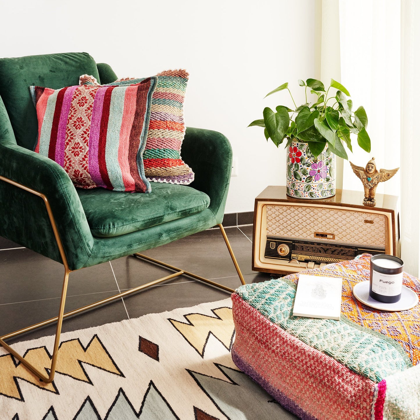 bunte Sitzecke mit Pouff und grünem Sessel