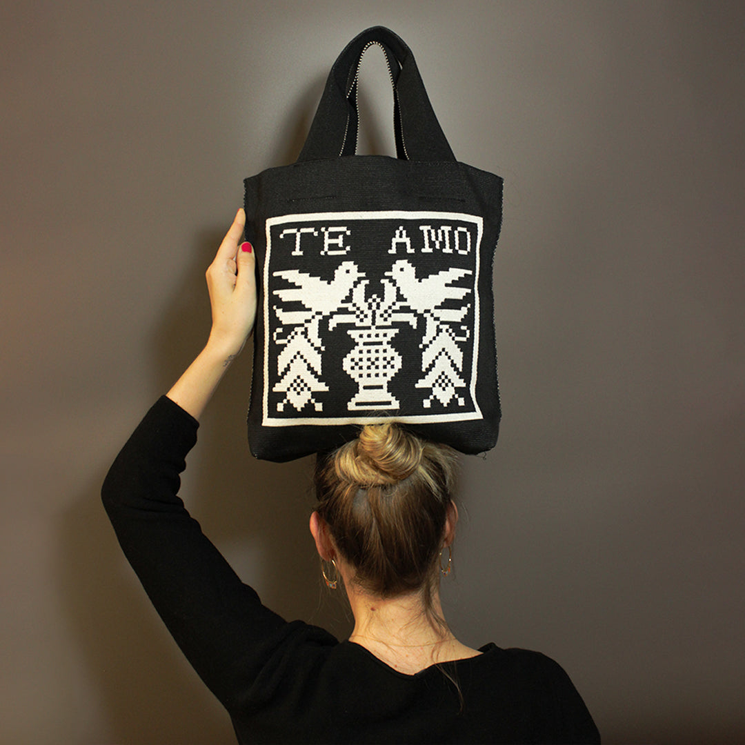 Schwarze Tasche mit Te Amo Motiv und Vögelchen auf grauem Hintergrund