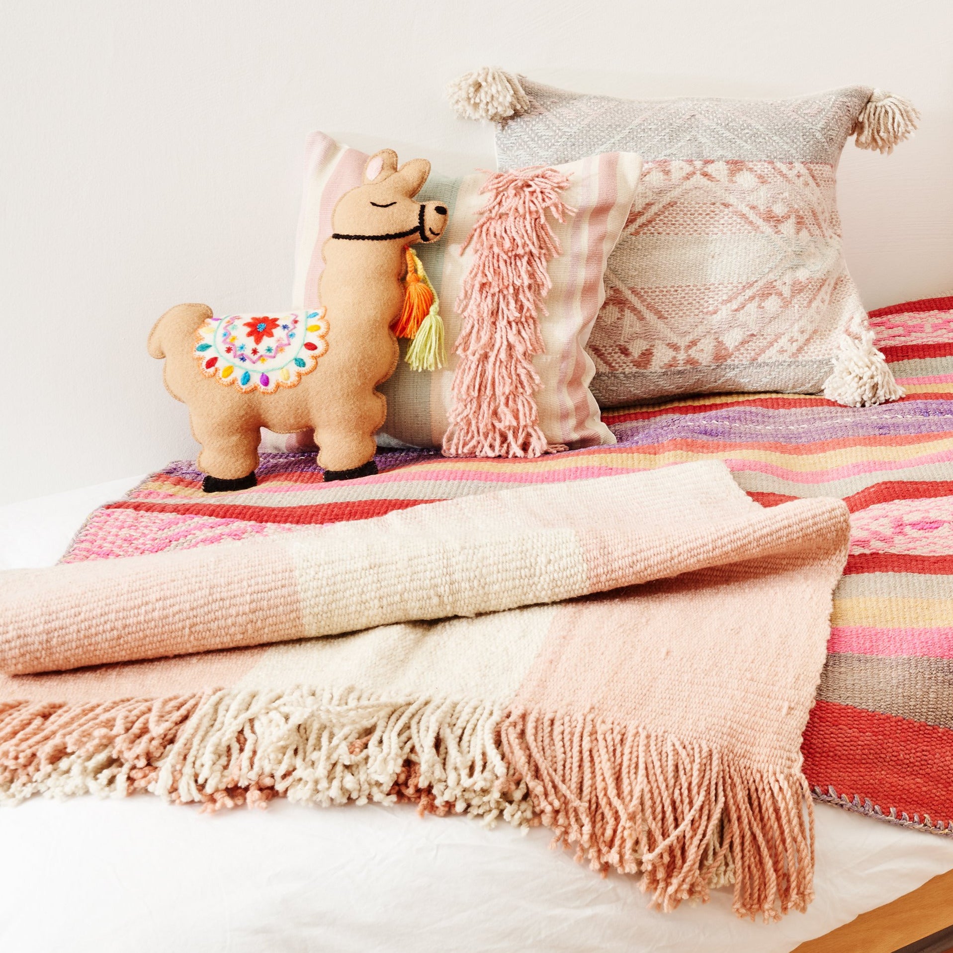 heimelige farbige Textilien in Rosa auf Kinderbett