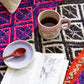 Teetasse mit Holzlöffel auf peruanischem Teppich