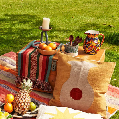 Picknick mit farbigen peruanischen Kissen, Decken und einer grossen Holzkiste bedeckt mit Früchten und Wasser