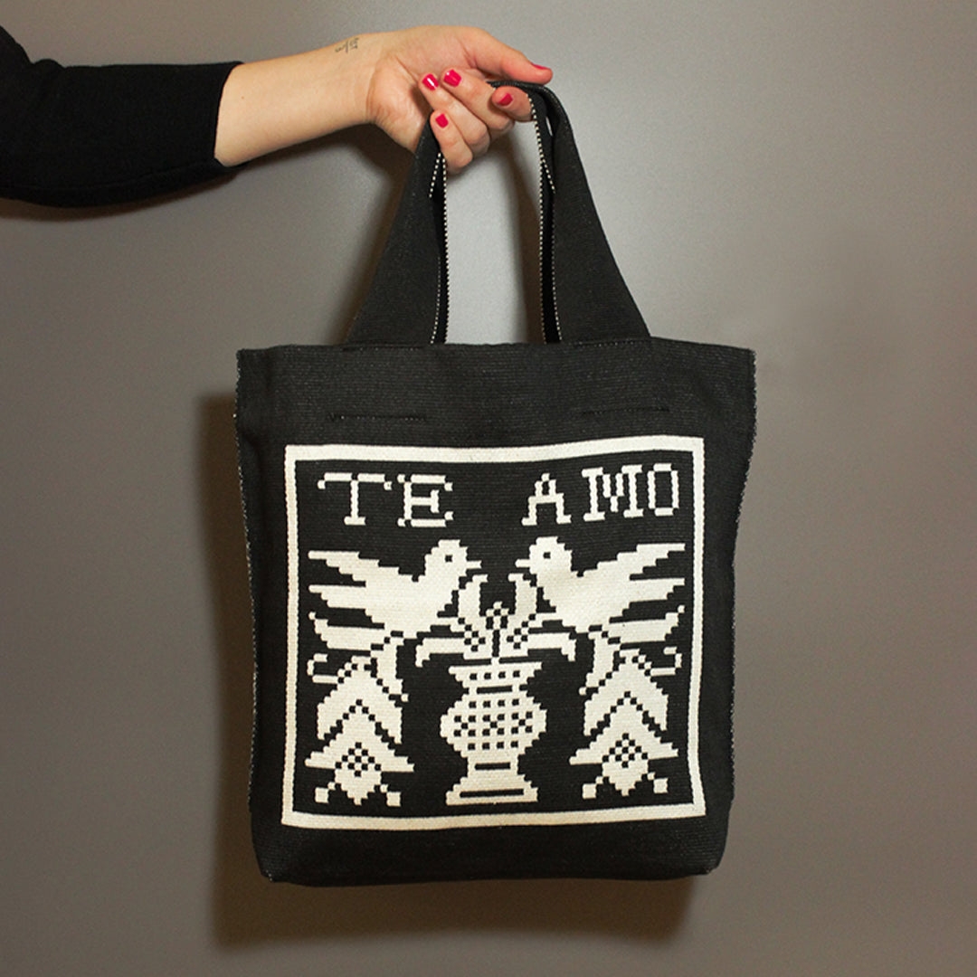 Schwarze Tasche mit Te Amo Motiv und Vögelchen auf grauem Hintergrund